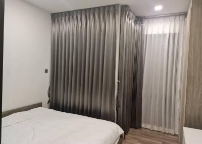 Bedroom with gray curtains and white bedspread