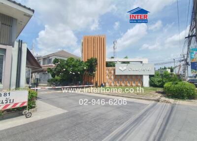 Front view of a residential building with entrance gate and surrounding area.