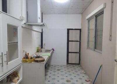 A bright kitchen with a patterned ceiling and tiled floor