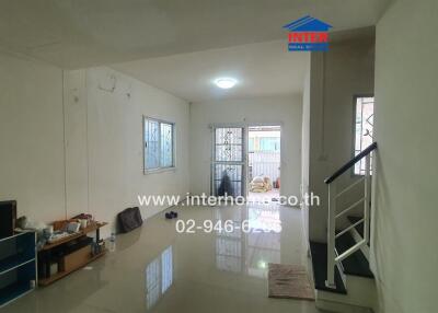 Main living space with visible staircase and entrance, painted in a light color