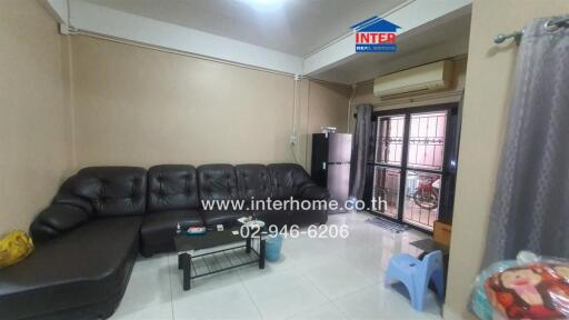 Comfortable living room with a black couch and glass coffee table