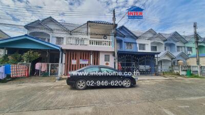 Front view of residential townhouses with a black car parked in front