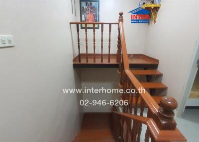 Staircase with wooden banister and small landing