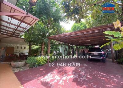 Covered parking area with car and surrounding greenery