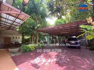 Covered parking area with car and surrounding greenery