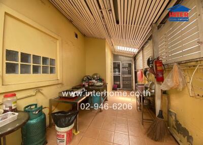 Outdoor kitchen area with various kitchen appliances and a gas cylinder