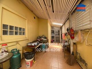 Outdoor kitchen area with various kitchen appliances and a gas cylinder