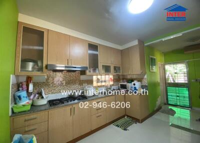 Modern kitchen with green walls, wood cabinets, and stainless steel appliances