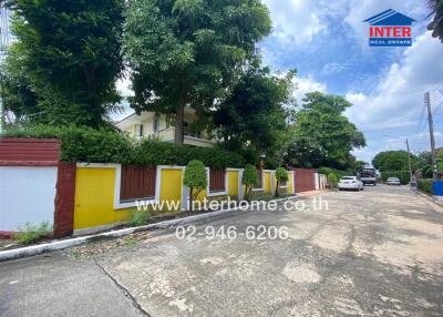 Exterior view of a residential building with colorful walls and lush greenery