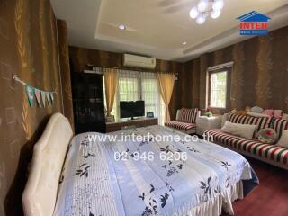 Spacious bedroom with large bed, seating area, and air conditioning