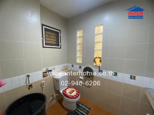 Bathroom with beige tiles, toilet, and basin