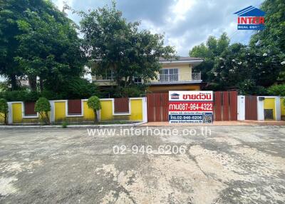 Front view of a property with gate and a real estate sign