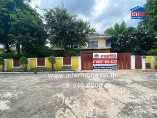 Front view of a property with gate and a real estate sign