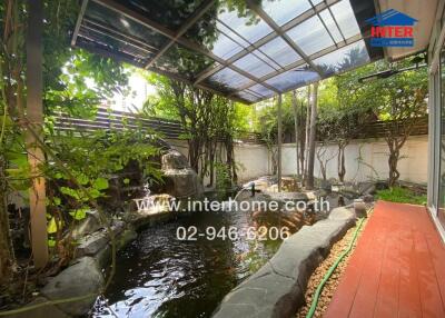 Peaceful backyard with pond and covered patio