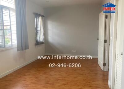 Empty bedroom with wooden floor and windows