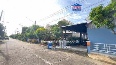 Street view of residential buildings with front gardens