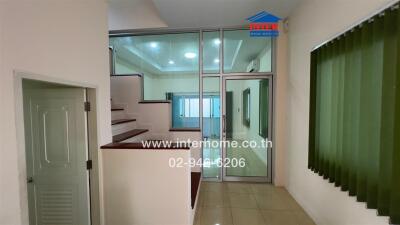 Staircase and small hallway with window and glass door