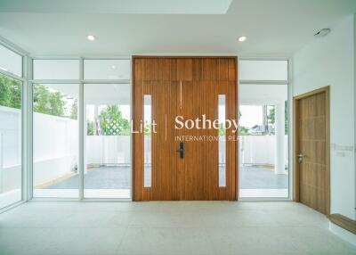 Modern entryway with large wooden doors and floor-to-ceiling windows