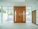 Modern entryway with large wooden doors and floor-to-ceiling windows