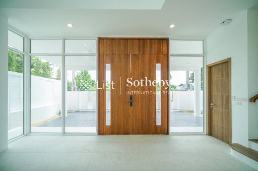 Modern entryway with large wooden doors and floor-to-ceiling windows