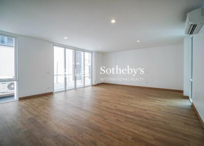 Spacious living room with large windows and wooden flooring