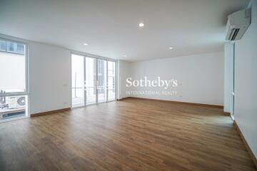 Spacious living room with large windows and wooden flooring