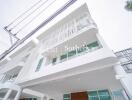 Modern three-story building exterior view with balconies