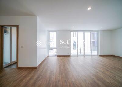 Spacious and well-lit living room with wooden flooring and large windows