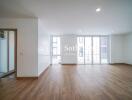 Spacious and well-lit living room with wooden flooring and large windows