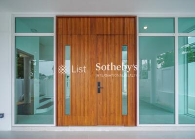 Modern wooden front door with glass panels and side windows