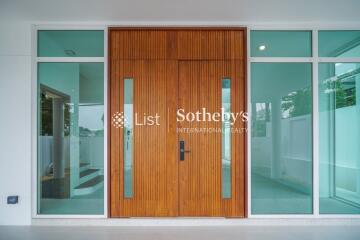 Modern wooden front door with glass panels and side windows