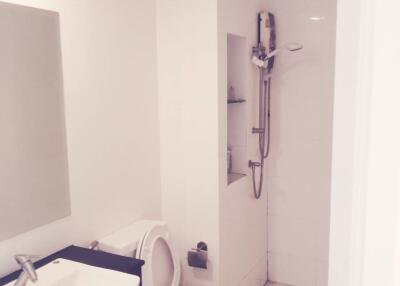 Modern white bathroom with sink, toilet, and shower area