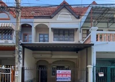 Front exterior view of a two-story house with a gated entrance and a tiled roof