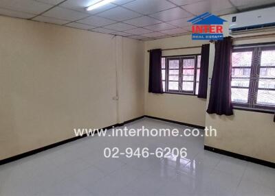 Empty bedroom with tiled flooring and two windows