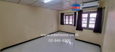 Empty bedroom with tiled flooring and two windows