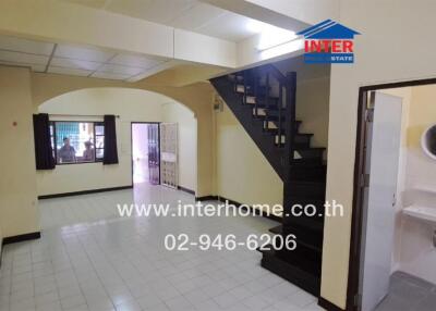 Main living area with staircase and entrance to bathroom