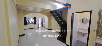 Main living area with staircase and entrance to bathroom