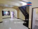 Main living area with staircase and entrance to bathroom