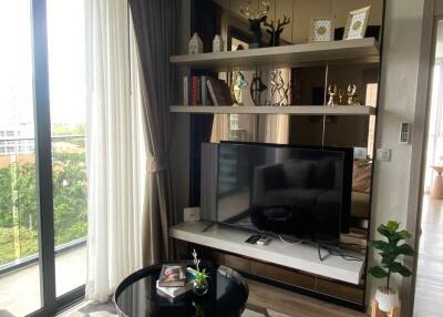 Modern living room with large window, TV, and decorative shelves