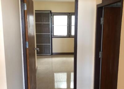 Interior view of a corridor leading to another room with windows