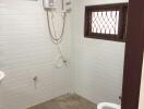 Bathroom with tiled walls and floor, showerhead, and a toilet