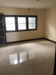 Spacious empty living room with tiled floor and barred windows