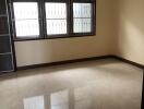 Spacious empty living room with tiled floor and barred windows