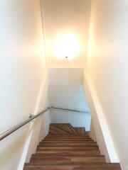 Well-lit staircase with wooden steps and modern handrail