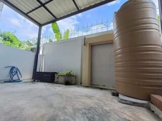 Covered outdoor area with water tank and plants