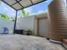 Covered outdoor area with water tank and plants