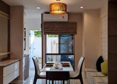 Modern dining room with a table set for four and large windows providing natural light