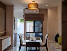 Modern dining room with a table set for four and large windows providing natural light