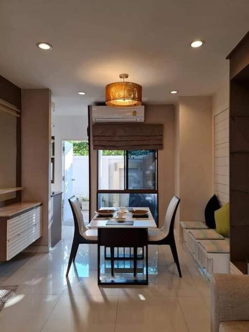 Modern dining room with a table set for four and large windows providing natural light