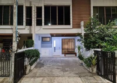 Front view of a modern townhouse with a driveway and gated entrance